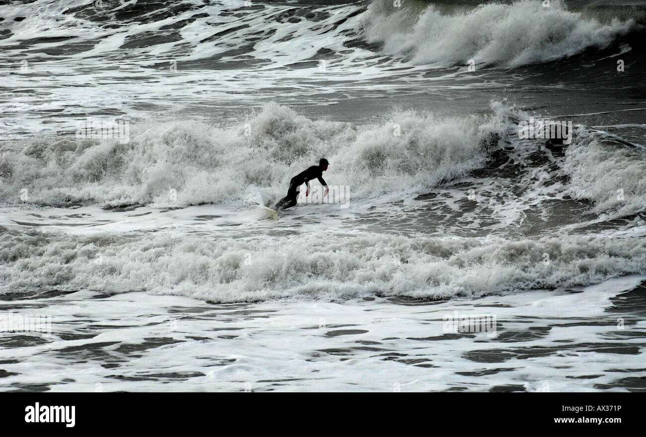 Un surfeur en combinaison isothermique COMPLÈTE SURF JOUIT EN FÉVRIER À CHALLABOROUGH BAY, PRÈS DE BIGBURY ON SEA,ANGLETERRE,UK. Banque D'Images
