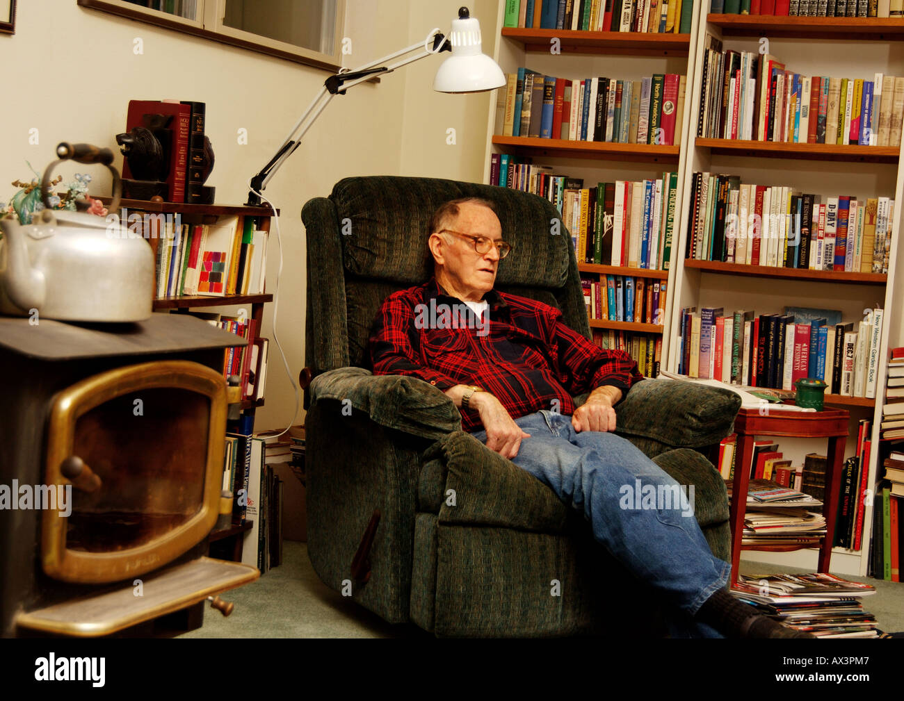 Un homme âgé se reposant sur un fauteuil dans son étude Banque D'Images
