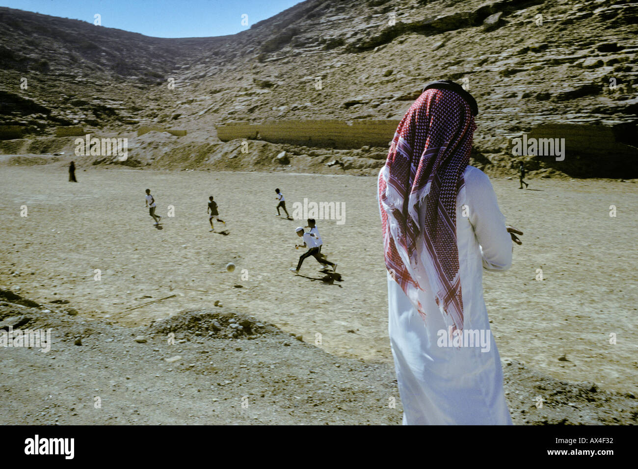 Le football sur un terrain désertique au bord d'un village de l'Arabie Banque D'Images