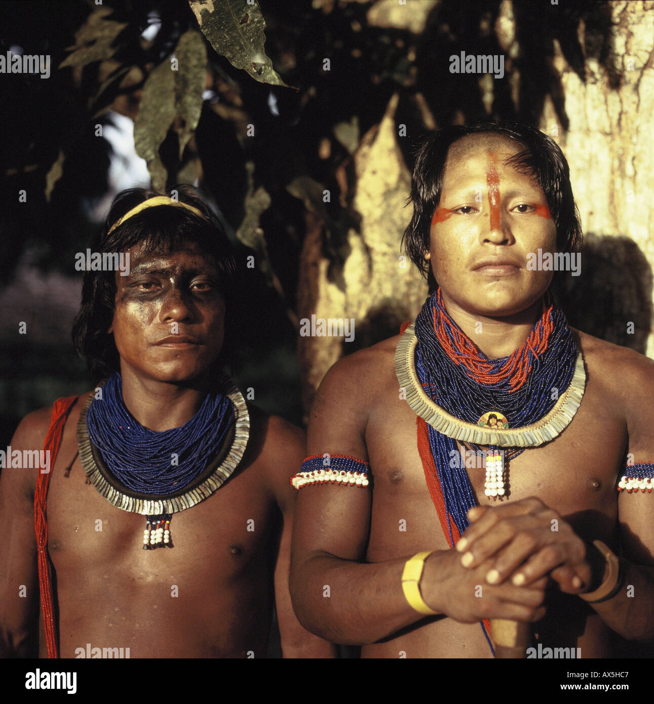 Xingu, au Brésil. Deux jeunes hommes portant des Kayapos perles bleues, colliers de coquillages et d'urucum et genipapo face paint. Banque D'Images