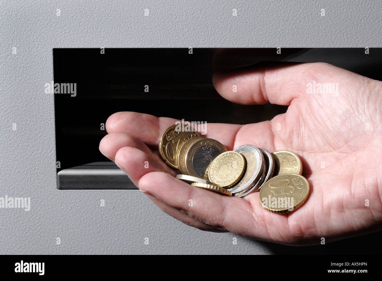 Main tenant les pièces en euros devant un distributeur automatique Photo  Stock - Alamy