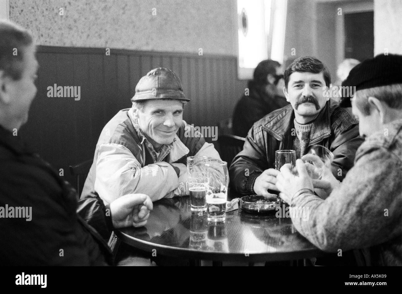 Katowice, Pologne. Groupe de mineurs assis autour de la table de bar bière potable de lunettes. Banque D'Images