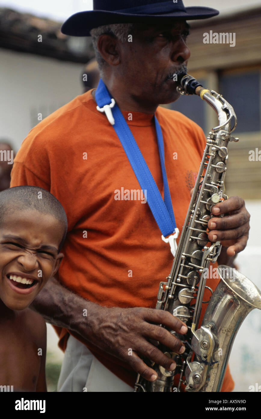 L'île de Itaparica, Etat de Bahia, Brésil. Homme jouant un saxophone dans une procession de la rue. Banque D'Images