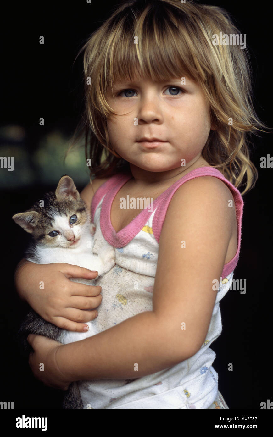 Péninsule d'Osa, au Costa Rica. Milagro, une fille blonde, tenant un chaton. Banque D'Images
