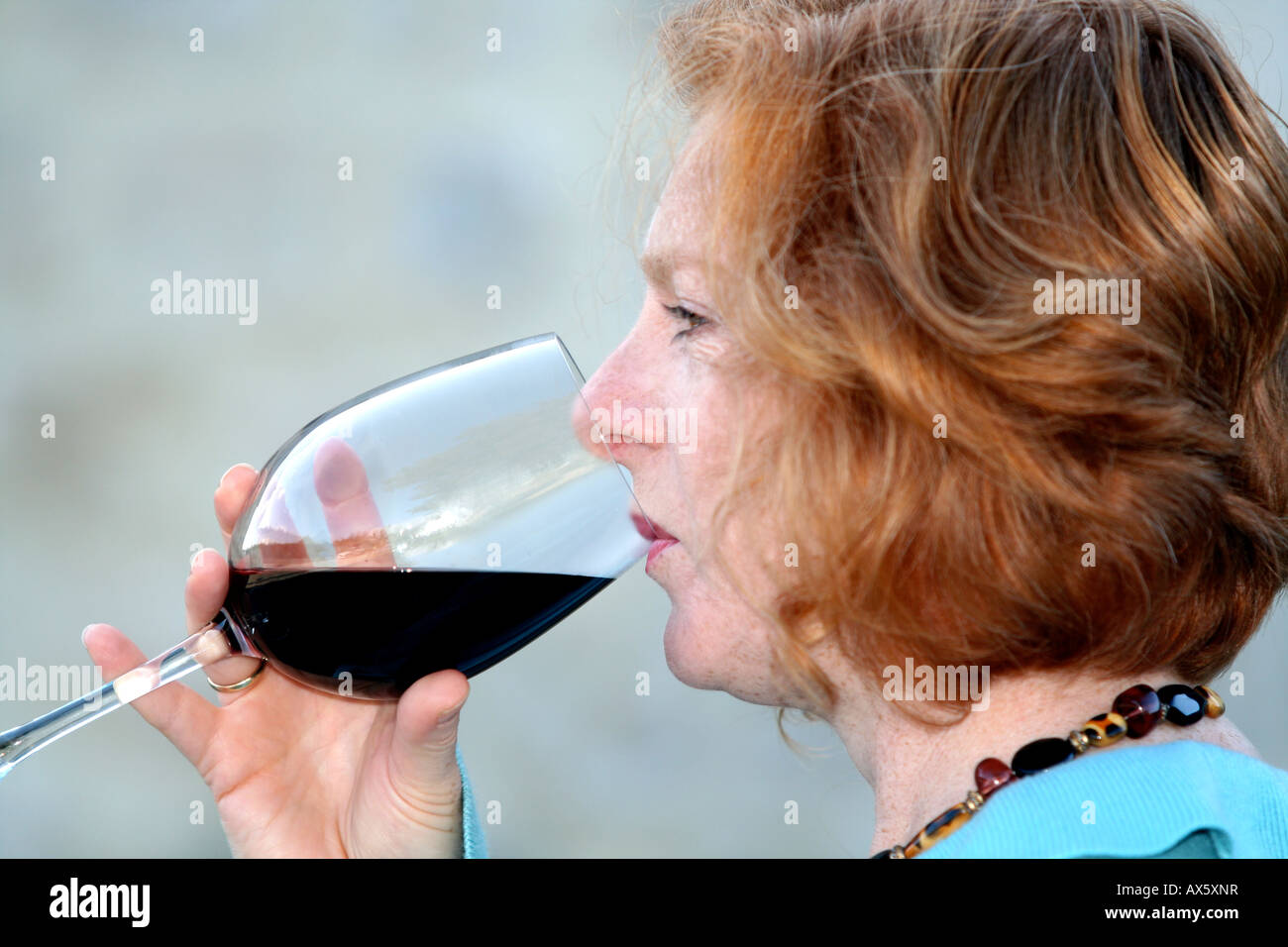 Jeune femme de boire un verre de vin rouge Banque D'Images