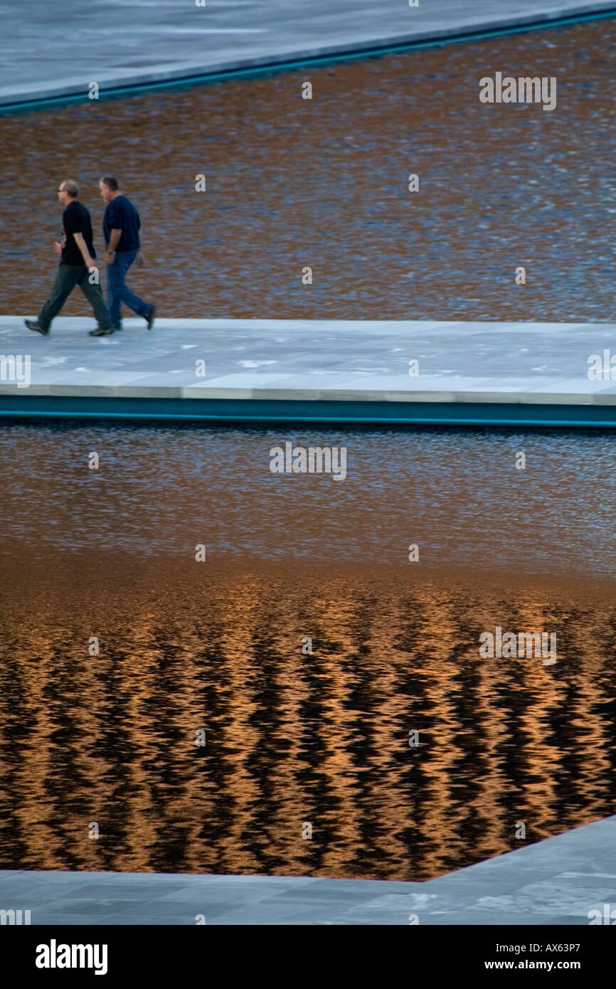 Deux hommes marcher par des bassins à l'Empire State Plaza Albany New York Banque D'Images