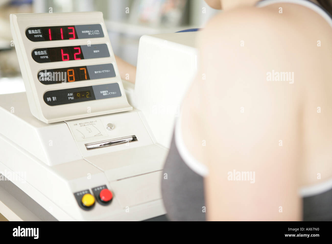 Une femme regarde au-dessus de la lecture d'un indicateur numérique dans la salle de sport Banque D'Images