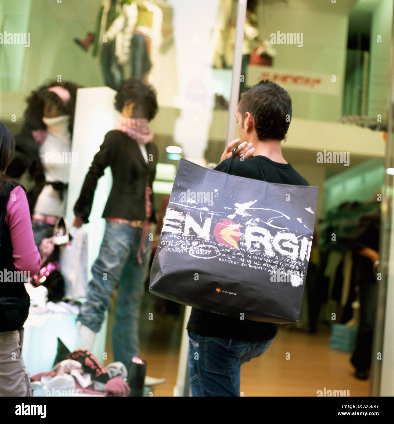 Jeune homme avec housse de transport et le logo Energii window shopping dans la Via del Corso, Rome KATHY DEWITT Banque D'Images