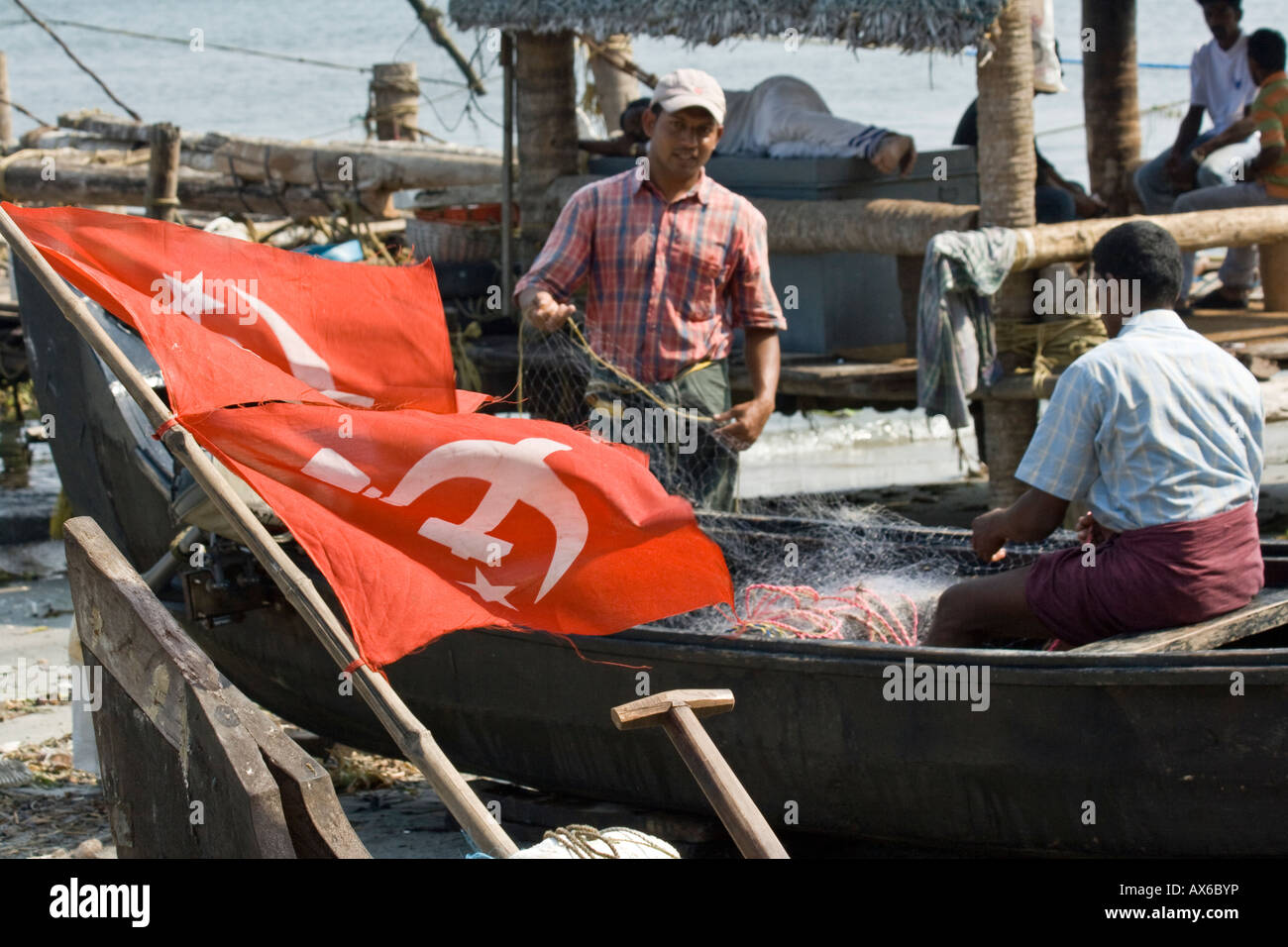Drapeau communiste et le pêcheur de la préparation des filets dans Cochin Inde Banque D'Images