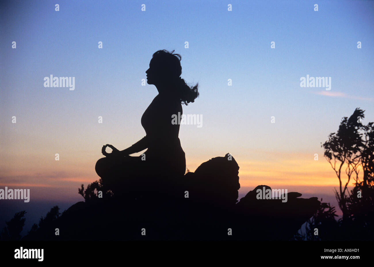 La méditation, la jeune fille dans la méditation en plein air au coucher du soleil. La paix, l'harmonie et la spiritualité. Banque D'Images