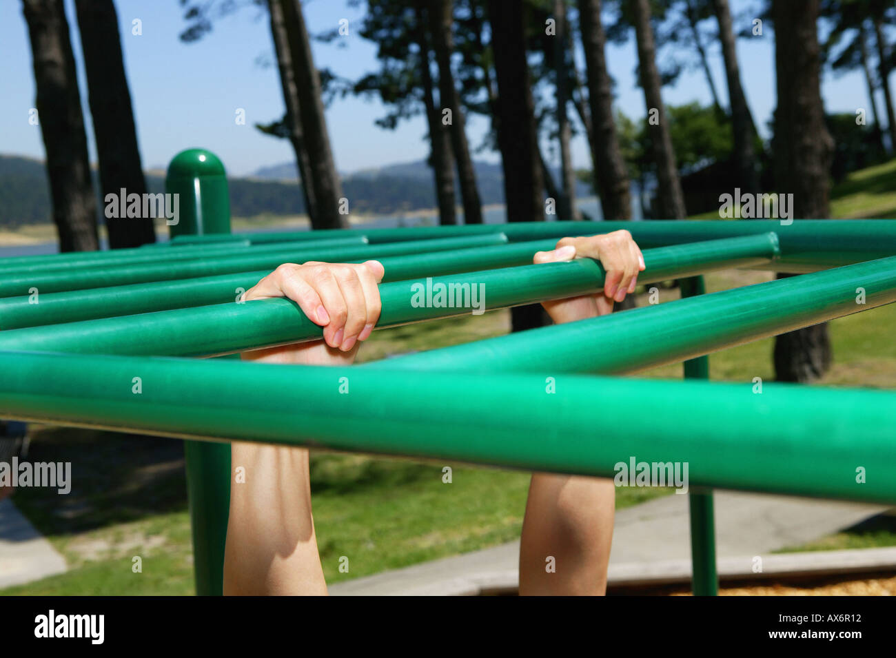 Personne accrochant sur monkey bars Banque D'Images