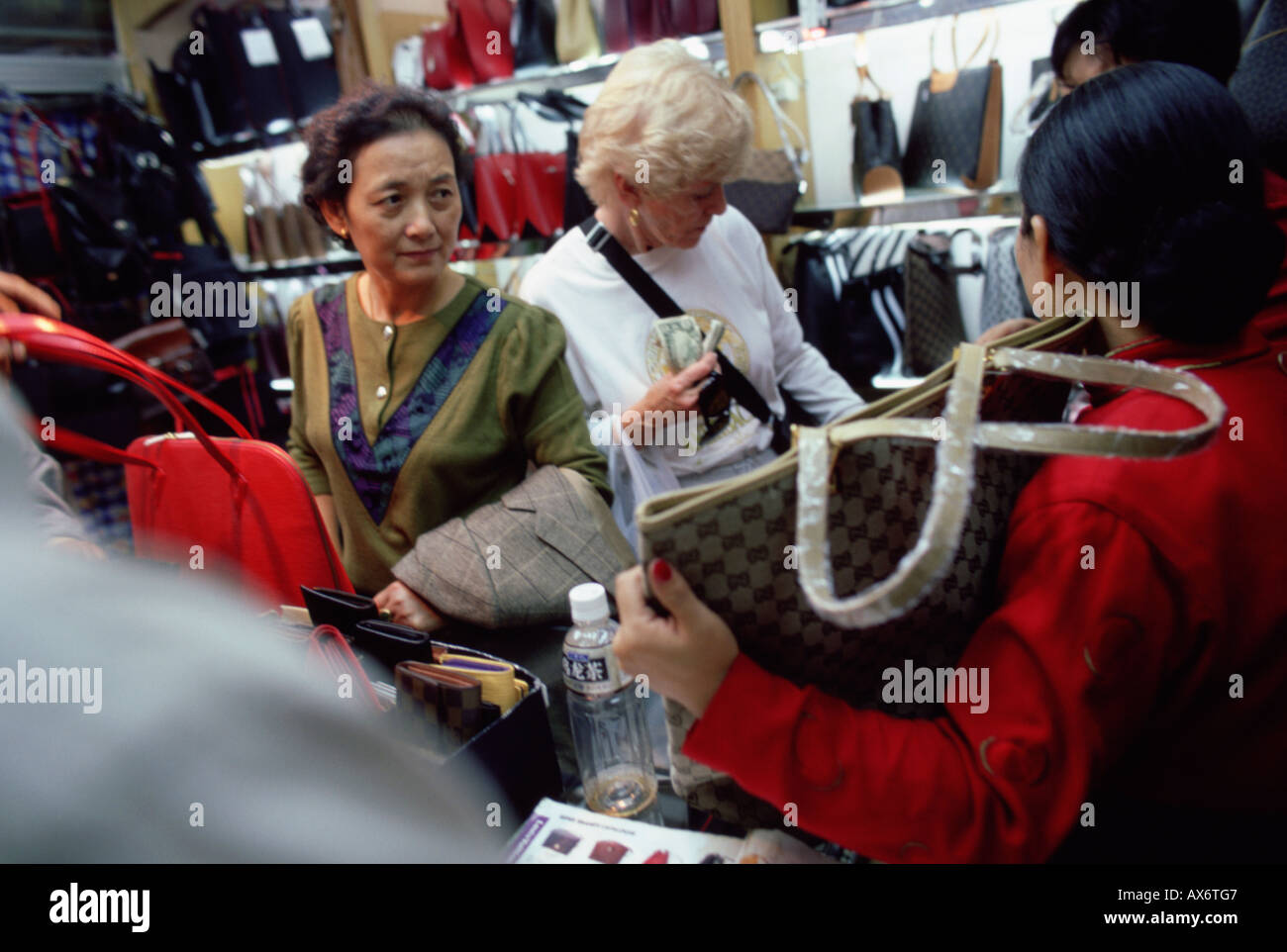 Les touristes américains l'achat de faux produits de luxe counterfit dans un marché à Shanghai le célèbre marché de Xiangyang Banque D'Images