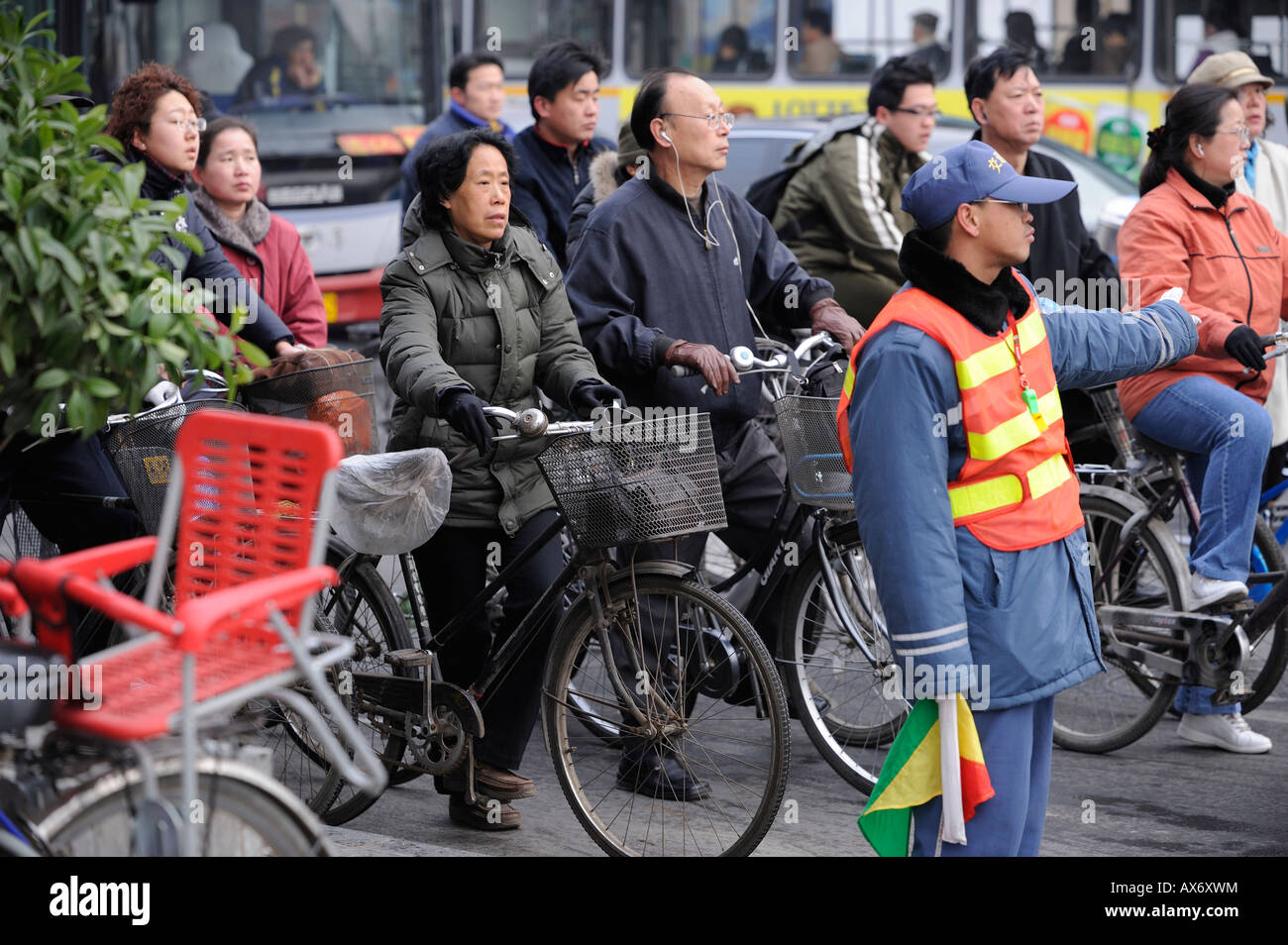 Un homme essayant de garder les cyclistes Suivant la règle de la circulation à un passage à niveau à Beijing, Chine. 20-Mar-2008 Banque D'Images