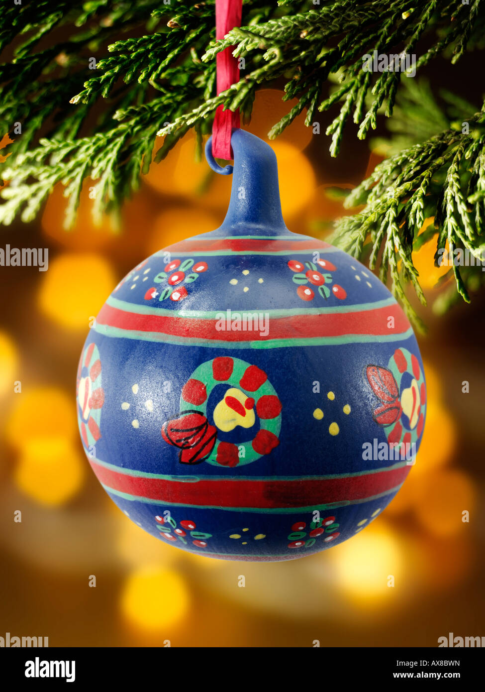 Boule de Noël traditionnelle à la décoration festive accrochée à un sapin de Noël avec lumières derrière Banque D'Images