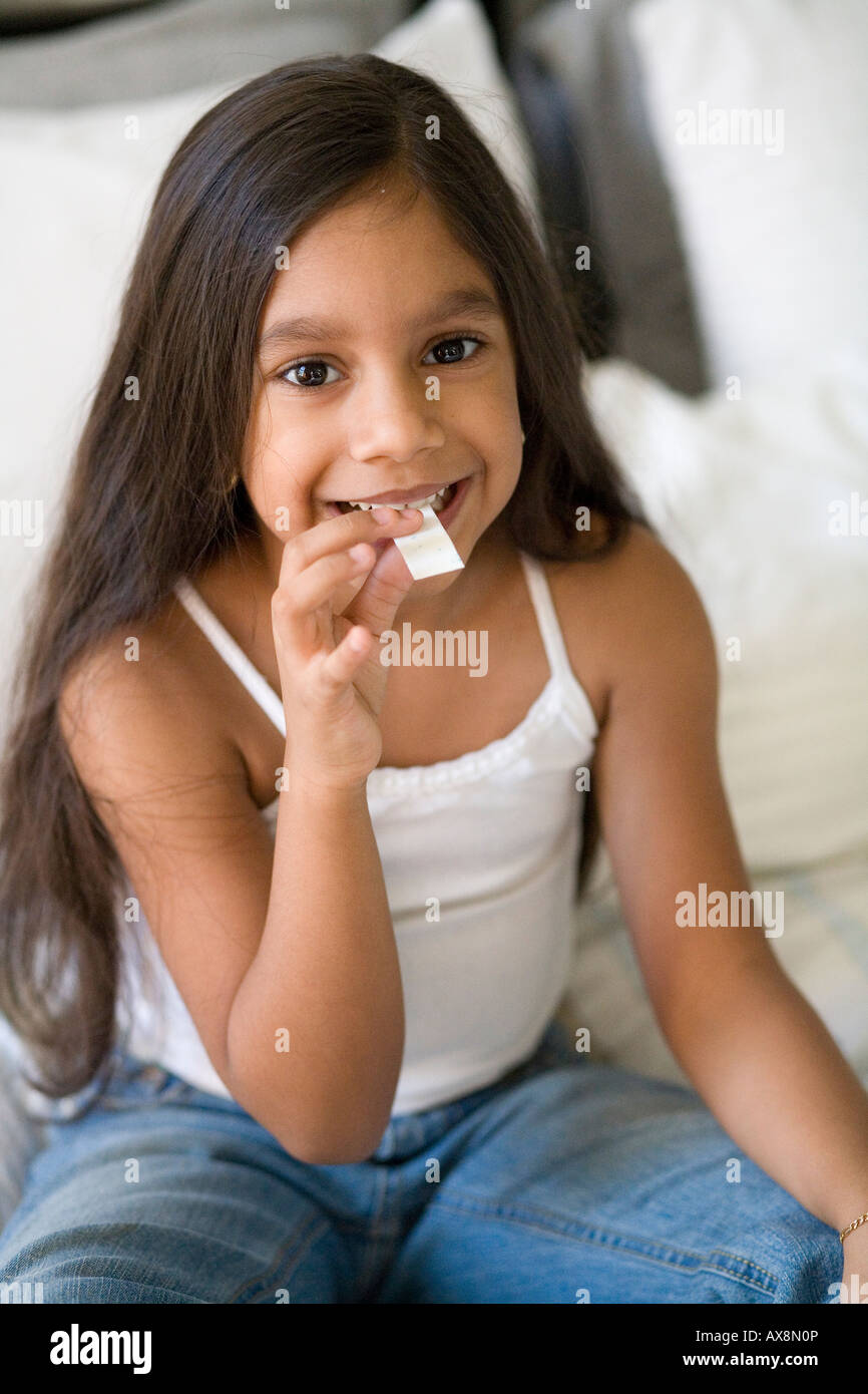 Fille avec un morceau de chewing-gum dans sa bouche. Banque D'Images
