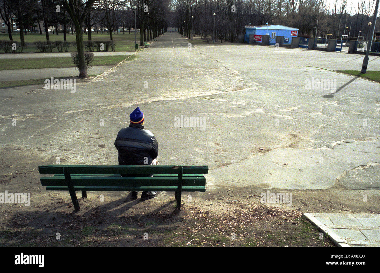 Un homme seul assis sur un banc de parc à Poznan, Pologne Banque D'Images
