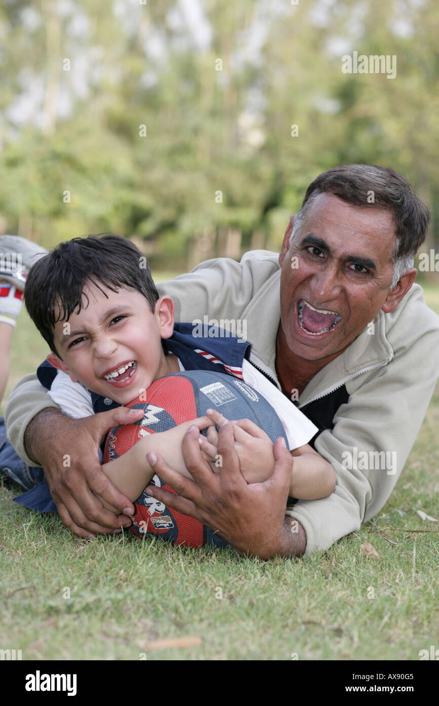 Portrait d'un homme et son petit-fils jouant avec une balle dans le parc Banque D'Images