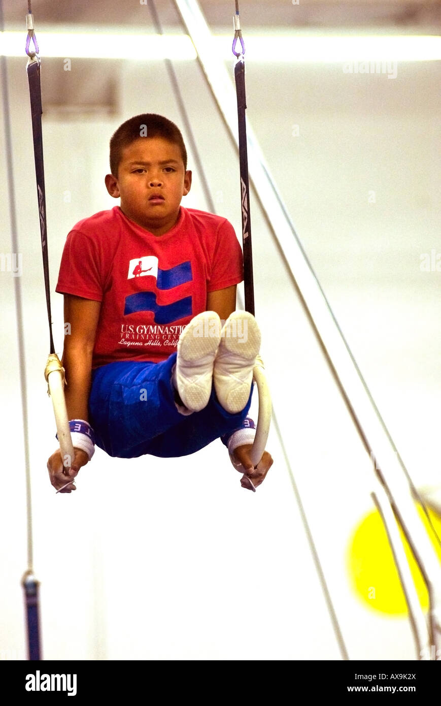 Boy fonctionne sur les anneaux de gymnastique au cours de la démonstration de répondre à U S Gymnastics Center California USA pas libéré Banque D'Images