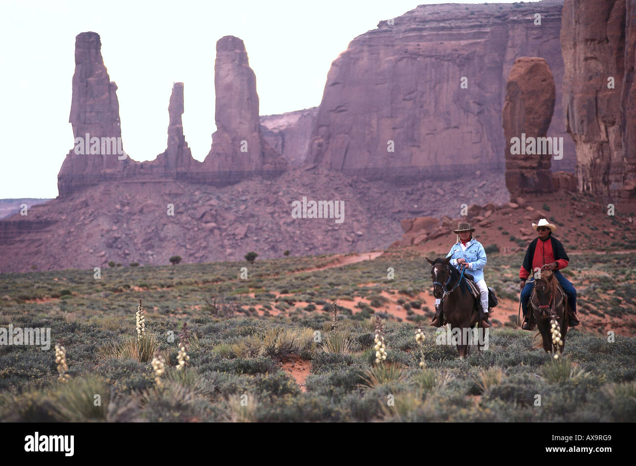 Deux personnes à cheval près de trois Sœurs, Monument Valley, Arizona, Utah, USA Banque D'Images