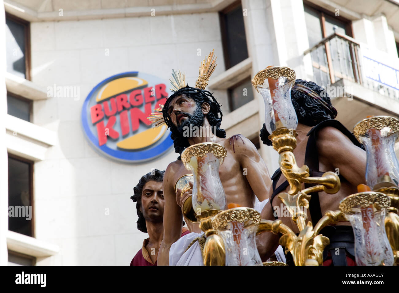 Une image du Christ en face de Burger King logo pendant les processions de la Semaine Sainte, Séville, Espagne Banque D'Images