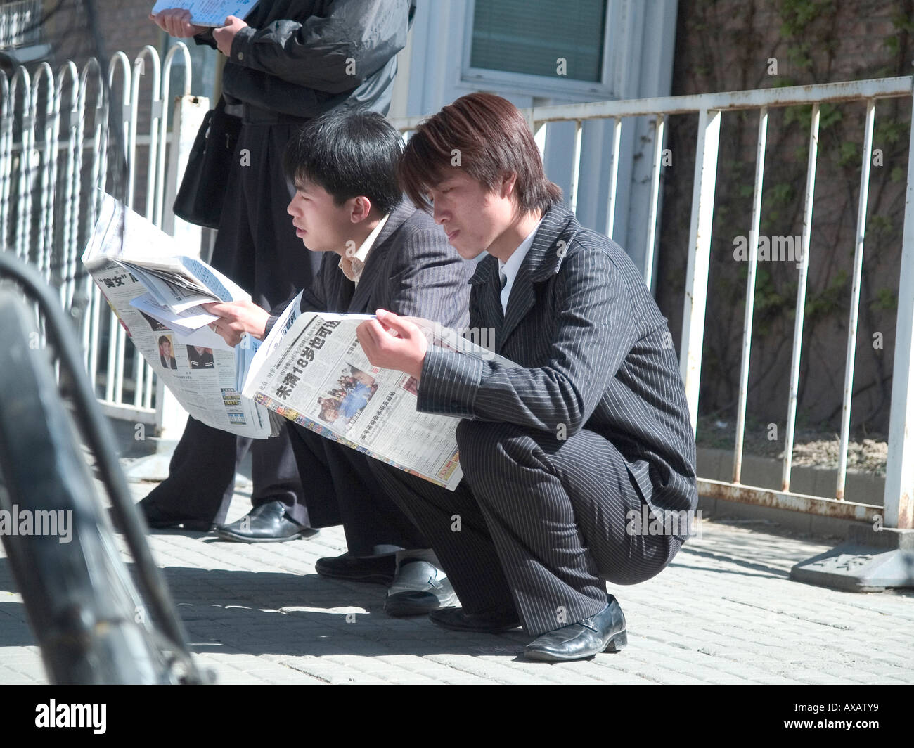 Les hommes de lire les journaux, Shanghai, Chine Banque D'Images