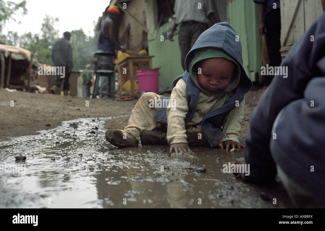 Les enfants de Kibera, le plus grand en Afrique jouent dans la boue. Nairobi, Kenya Banque D'Images