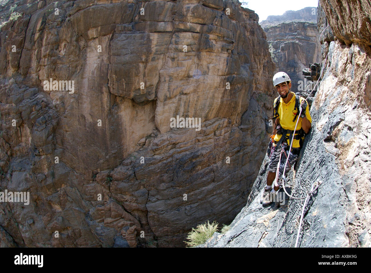 Un homme faisant la Via Ferrata randonnée dans Snake Canyon, partie de Wadi Bani Auf dans l'ouest de Jebel Akhdar montagnes Hajar en Oman. Banque D'Images