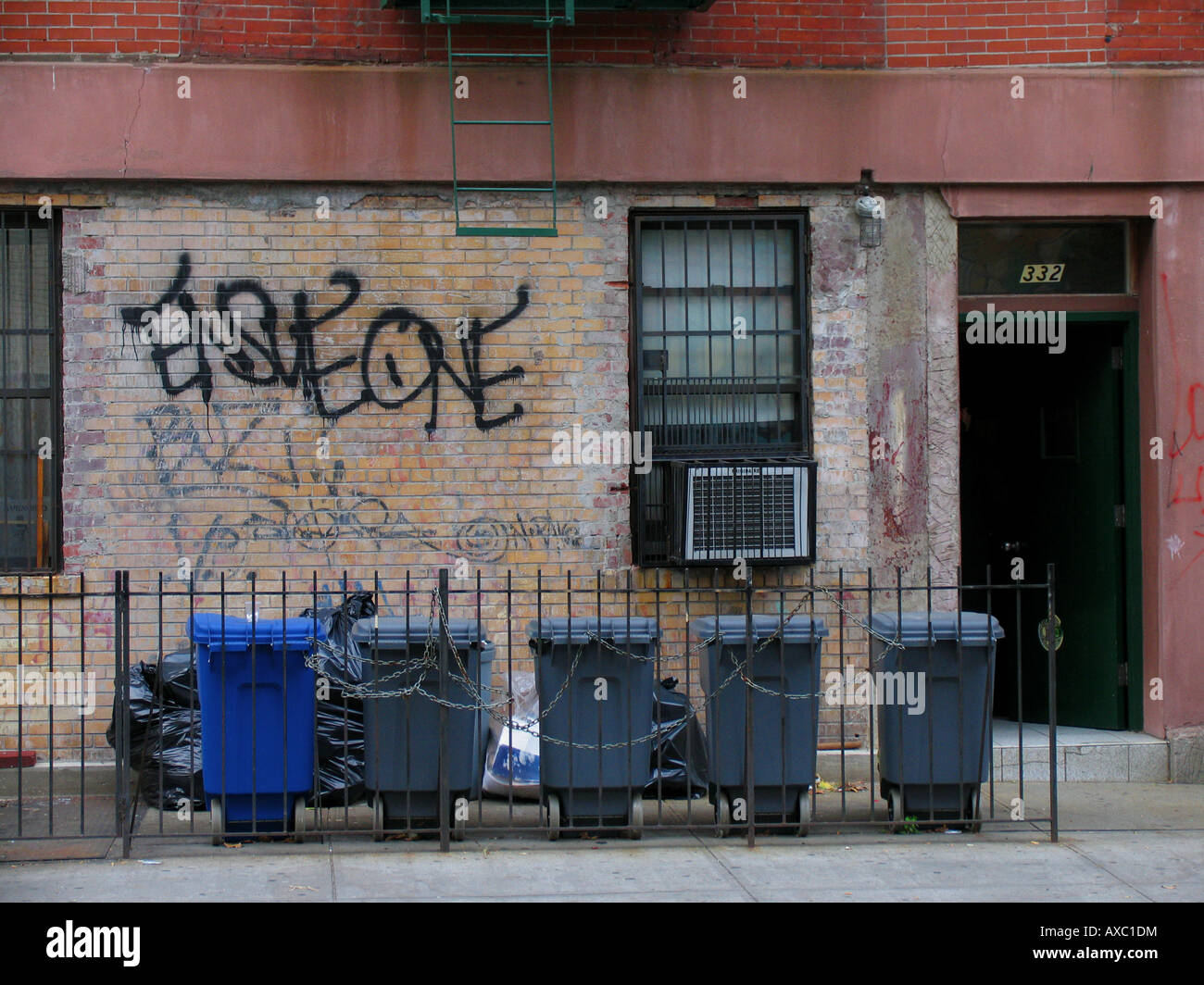Poubelles enchaînés devant un mur avec grafiti, États-Unis d'Amérique, Brooklyn, New York Banque D'Images