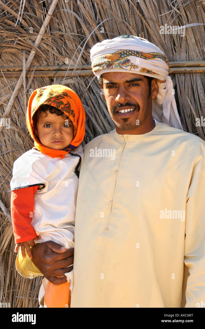 Un bédouin homme posant avec son enfant dans les Wahiba Sands en Oman. Banque D'Images