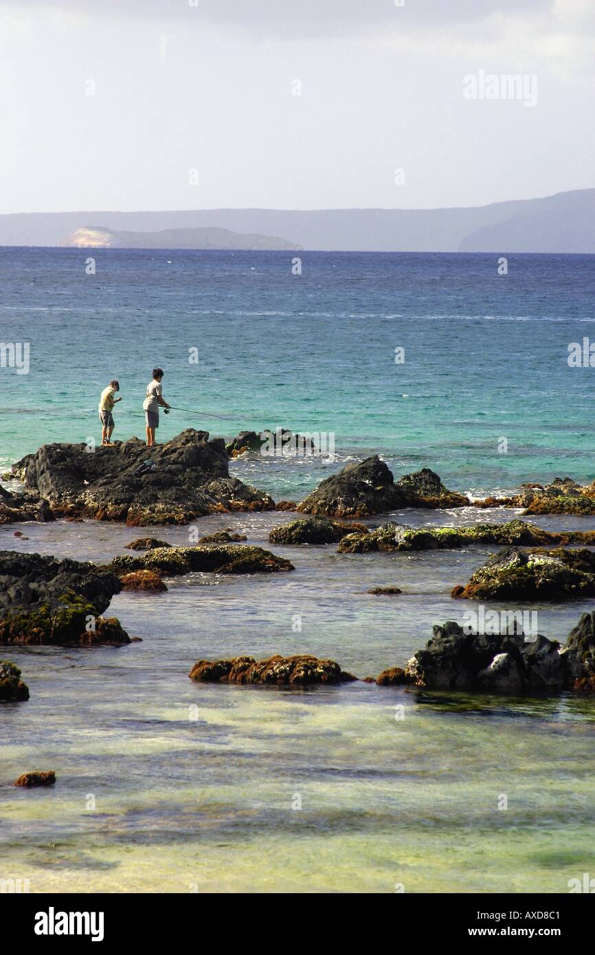 Les îles de Molokini et Kaho olawe sont l'arrière-plan de cette scène avec deux jeunes garçons Hawaii Maui Kihei pêche Banque D'Images