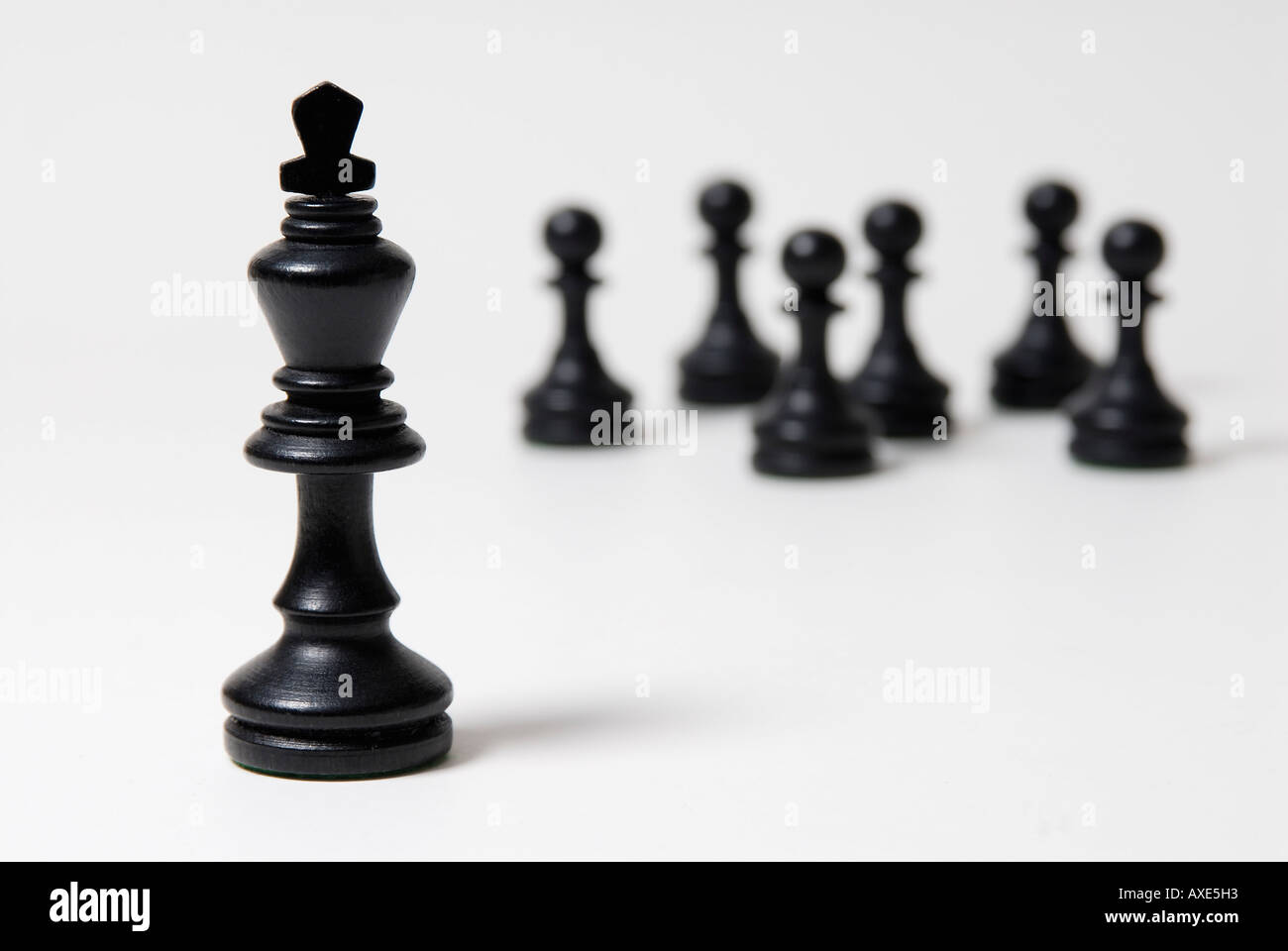 Les échecs, l'un roi noir se trouve en face d'un groupe de pions noirs, symbole de domination, de leadership Banque D'Images