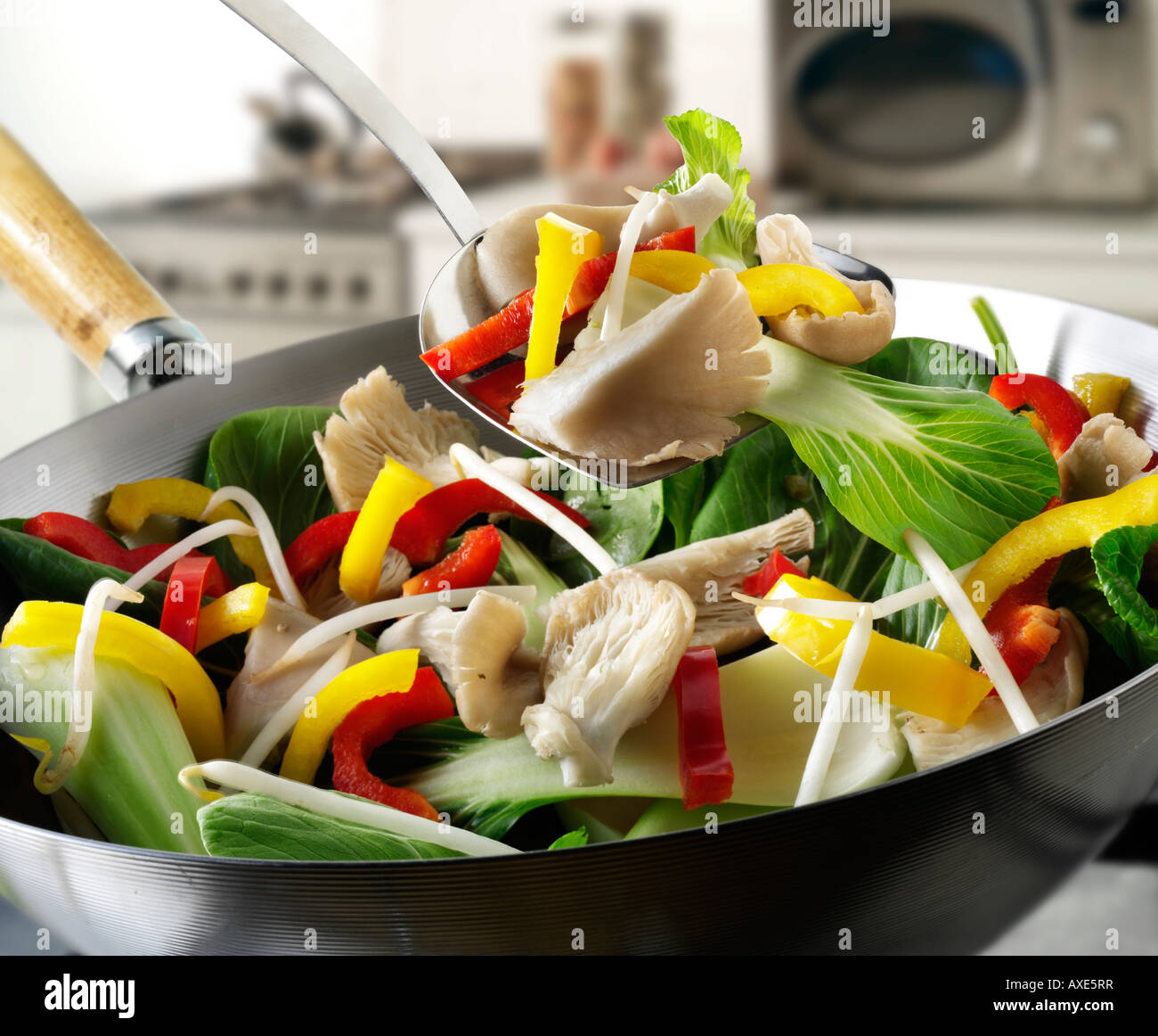 Sauté de légumes au wok étant brassé avec pleurotes, poivrons, pak choi et légumes Banque D'Images