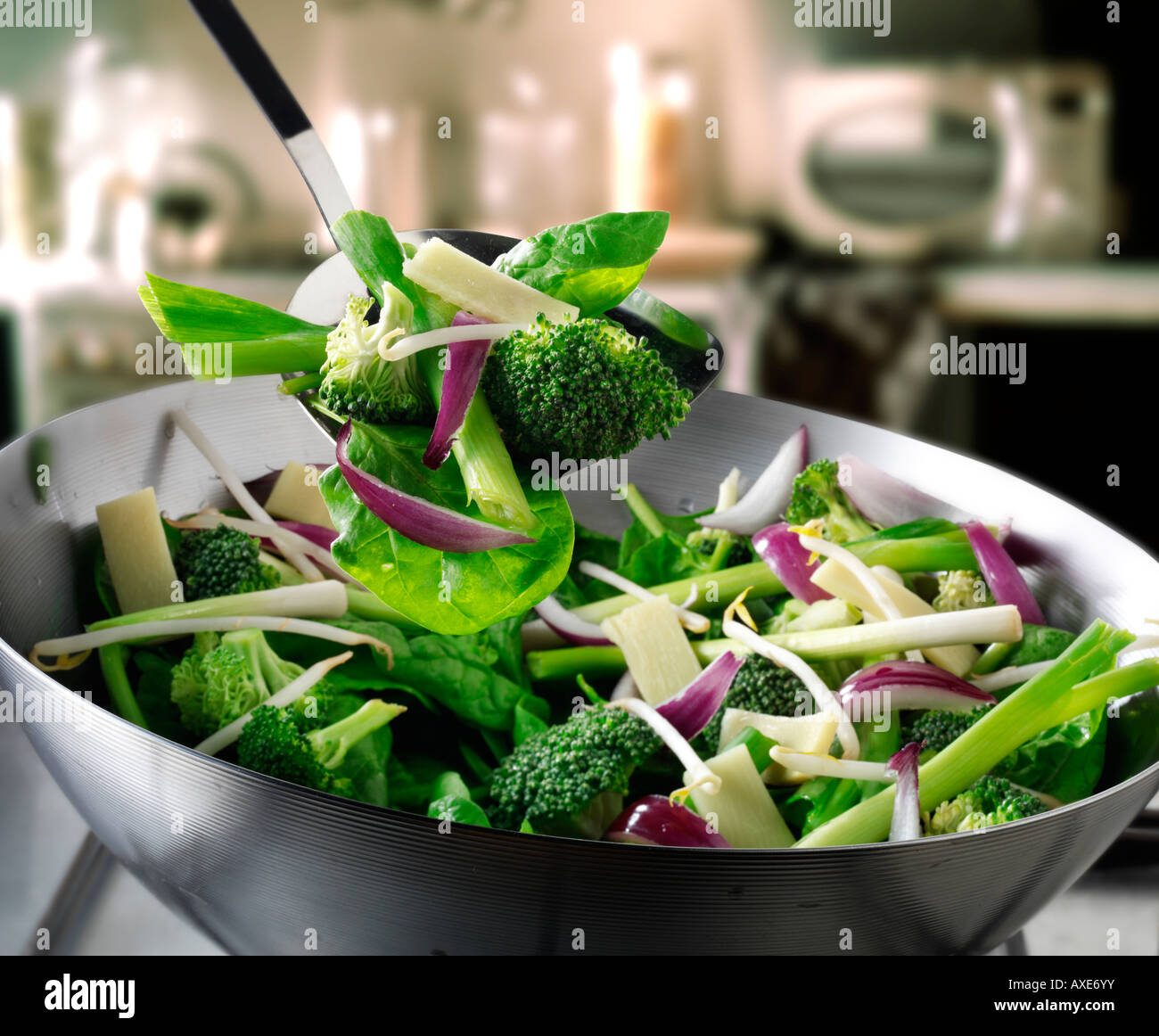 Sauté de légumes au wok étant brassé avec pak choi, oignons de printemps, les pousses de brocoli, haricots et légumes Banque D'Images