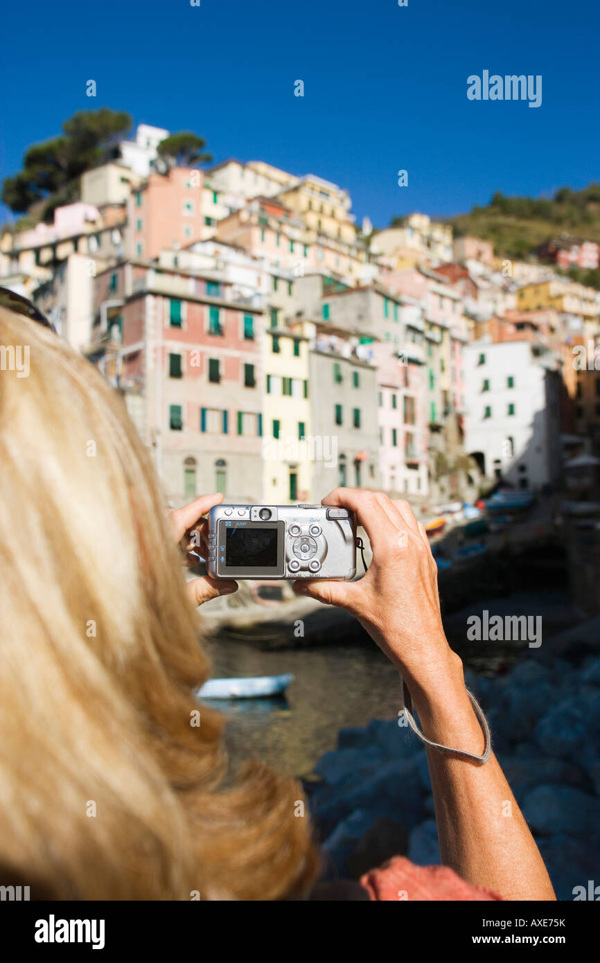 L'Italie, Ligurie, Riomaggiore, Woman photographing maisons Banque D'Images