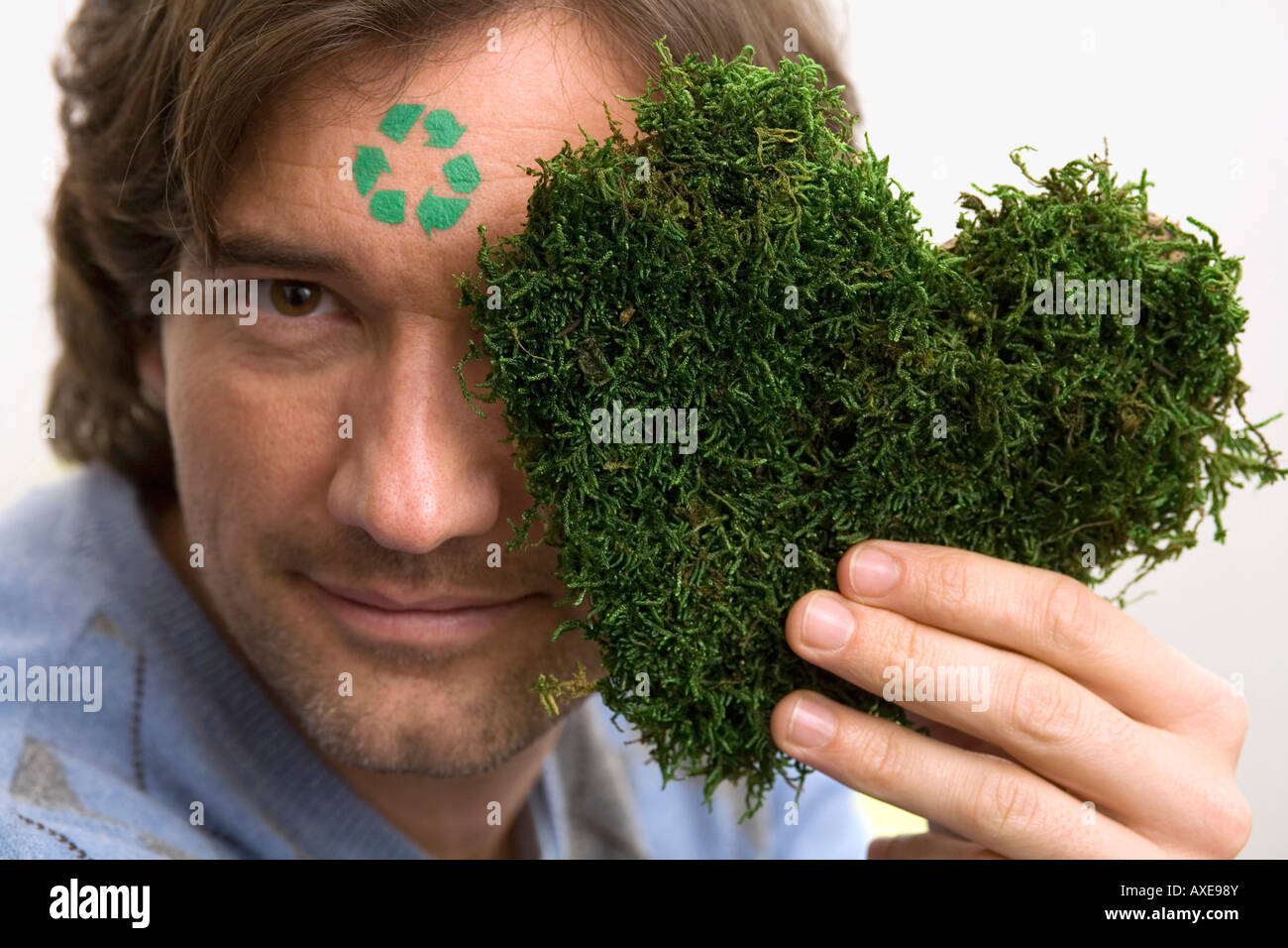 Homme avec panneau vert sur le front,herbe holding heart, portrait Banque D'Images