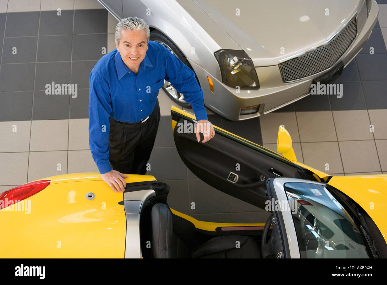 Vendeur de voiture hispaniques entrer dans nouvelle voiture Banque D'Images