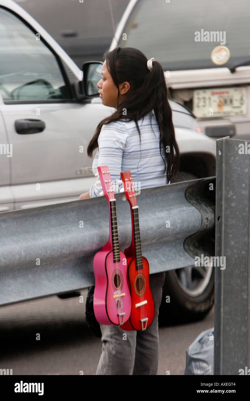 Le vendeur mexicain vend des bibelots colorés aux conducteurs et aux passagers qui attendent dans des véhicules au poste frontalier Mexique-États-Unis. Banque D'Images