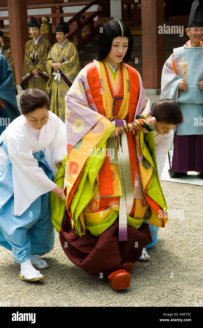 Fonctionnaires aider une femme habillé en costume d'époque Heian au pas Gokusui en festival à Hiraizumi Japon Iwate Banque D'Images