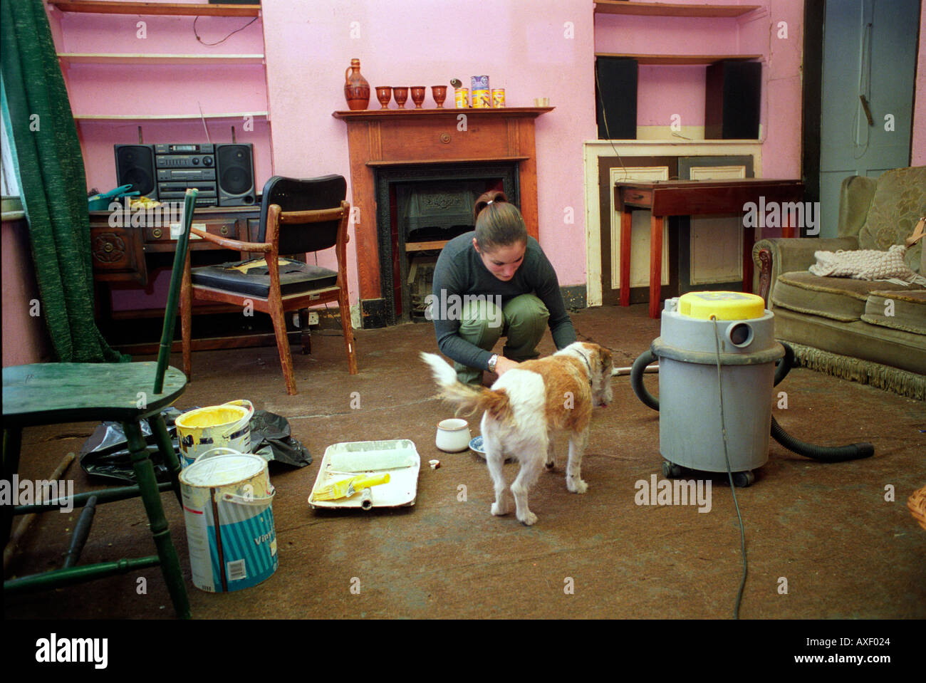 Jeune femme accroupie dans sa cuisine nettoyage maison qui elle a grandi et a vécu pendant 30 ans. Banque D'Images Jeune femme accroupie dans sa cuisine nettoyage maison qui elle a grandi et a vécu pendant 30 ans. Banque D'Images