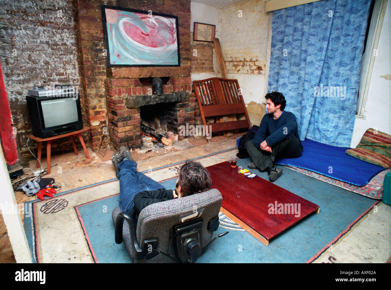 Regarder la télévision dans la soirée dans le sud de Londres, squat. Banque D'Images Regarder la télévision dans la soirée dans le sud de Londres, squat. Banque D'Images