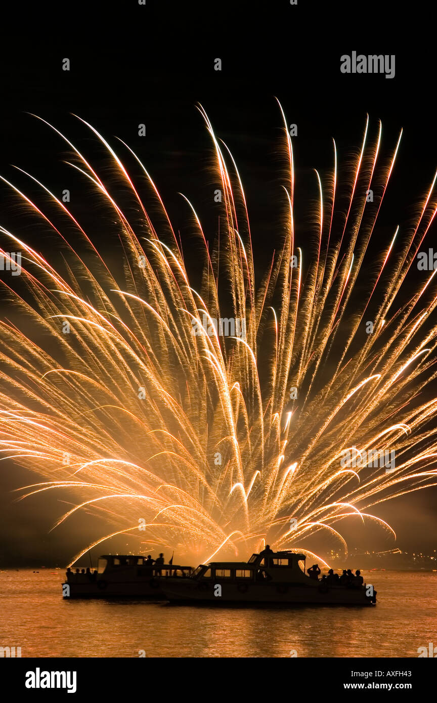 D'artifice burst dans l'océan derrière bateaux dans le port pendant la fête des lanternes Matsushima dans la préfecture de Miyagi au Japon Banque D'Images