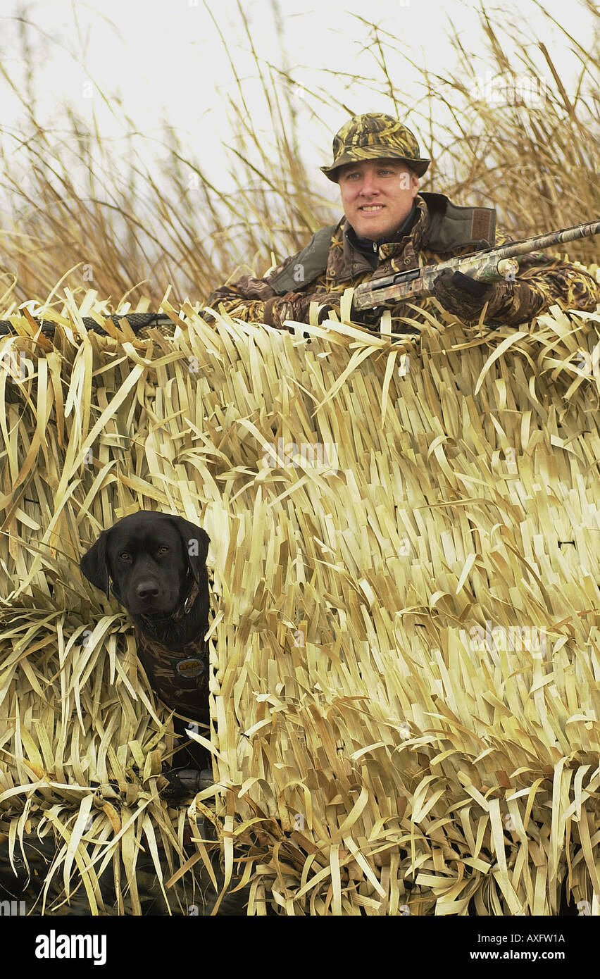 Steve Scherer de Waitsfield, VT, avec son chien Rufus vols attendent d'oiseaux dans leur bateau de canard comme il chasse les canards. Banque D'Images