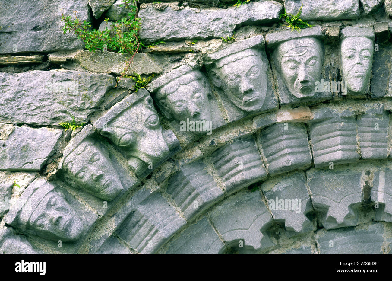 Têtes humaines et animales en pierre sculptée sur l'arche romane de la porte de l'ancienne église monastique à Dysert O'Dea, comté de Clare, Irlande Banque D'Images