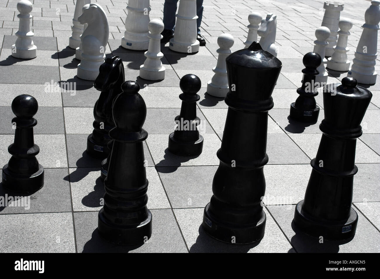 Noir et blanc géant peices d'échecs sur un échiquier à l'extérieur du centre-ville. Banque D'Images