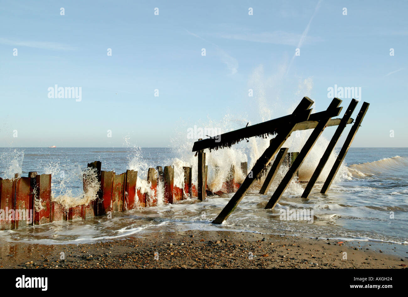 Vague Briser brisé et la rouille, les défenses maritimes Happisburgh, Norfolk, UK Banque D'Images