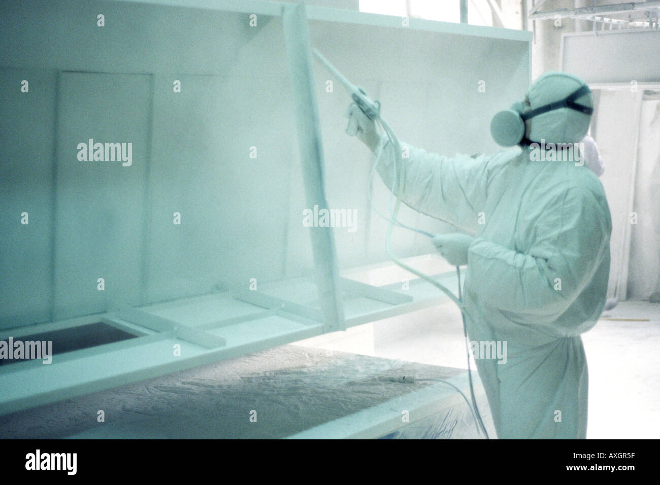Homme dans un combinaisons blanches dans une usine. Banque D'Images