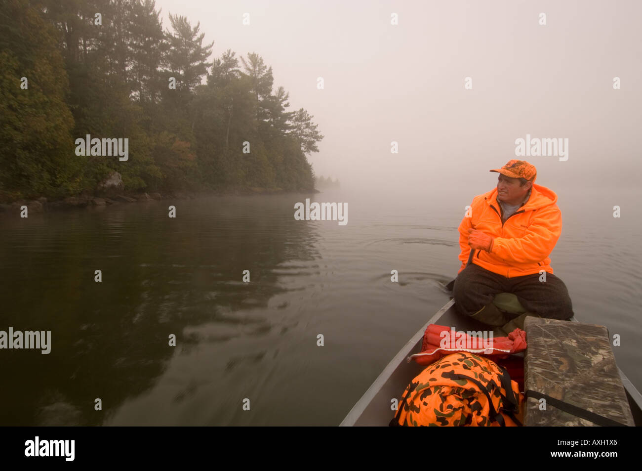 Un brasier dans DEER HUNTER PALES ORANGE SON ALUMACRAFT CANOË SUR UN LAC BRUMEUX LE NORD DU MINNESOTA Banque D'Images