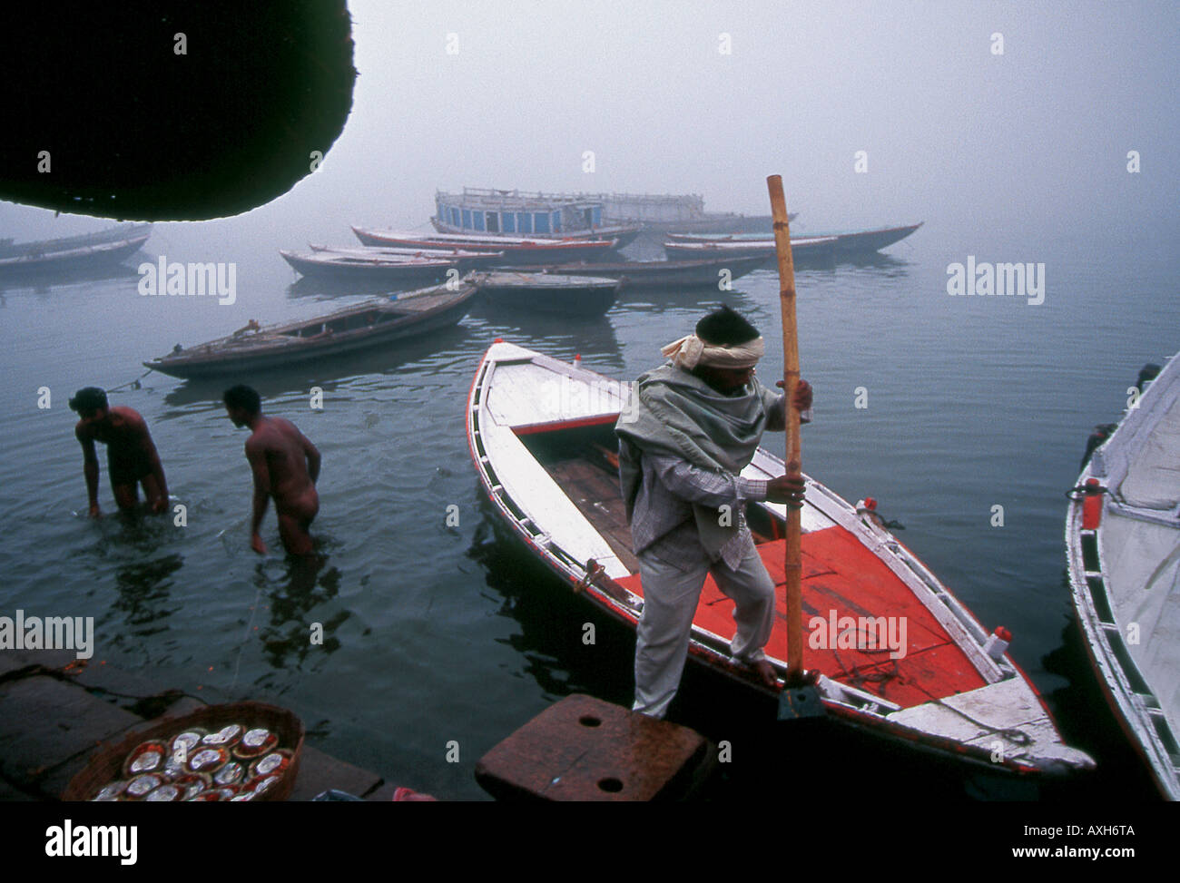 Les hindous la baignade et la préparation des bateaux pour les visiteurs souhaitent mettre des bougies sur Ganges Varanasi Inde Banque D'Images