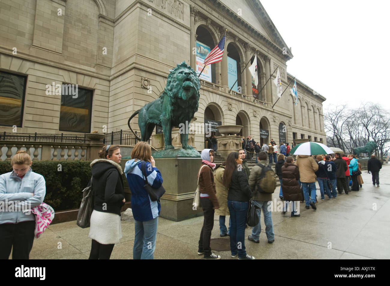 L'ILLINOIS Chicago Ligne de gens qui attendent pour entrer dans l'Art Institute de Chicago et pluvieuse journée humide sculptures lion à l'entrée Banque D'Images
