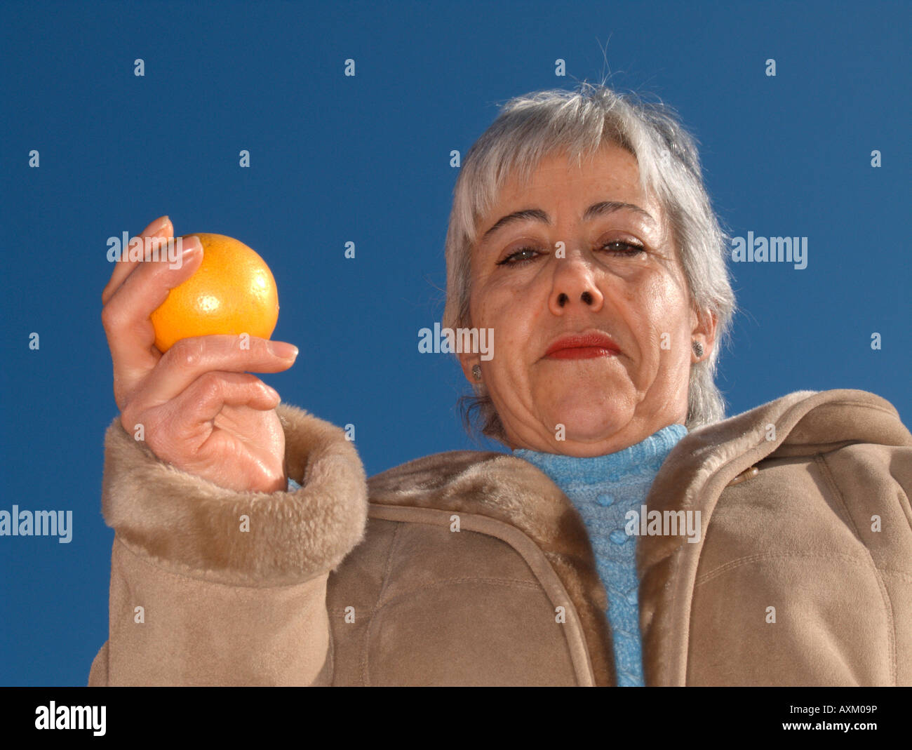 Portrait de femme adulte mature montrant une orange Banque D'Images